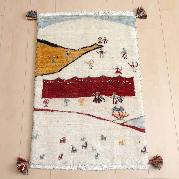 ギャッベ／ルリバフ 83×56cm（HSS-73209）は、色とりどりの模様が施されたペルシャ絨毯が木目の床に敷かれ、手織りウールの柔らかさと暖かみが際立っている。