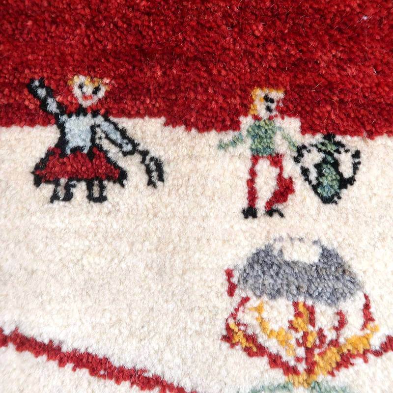 赤と白の鮮やかな手織りのギャッベラグに描かれた可愛らしい人物模様が、ウールの温かみとともに専門店通販で購入できるペルシャ絨毯の魅力が際立っている。