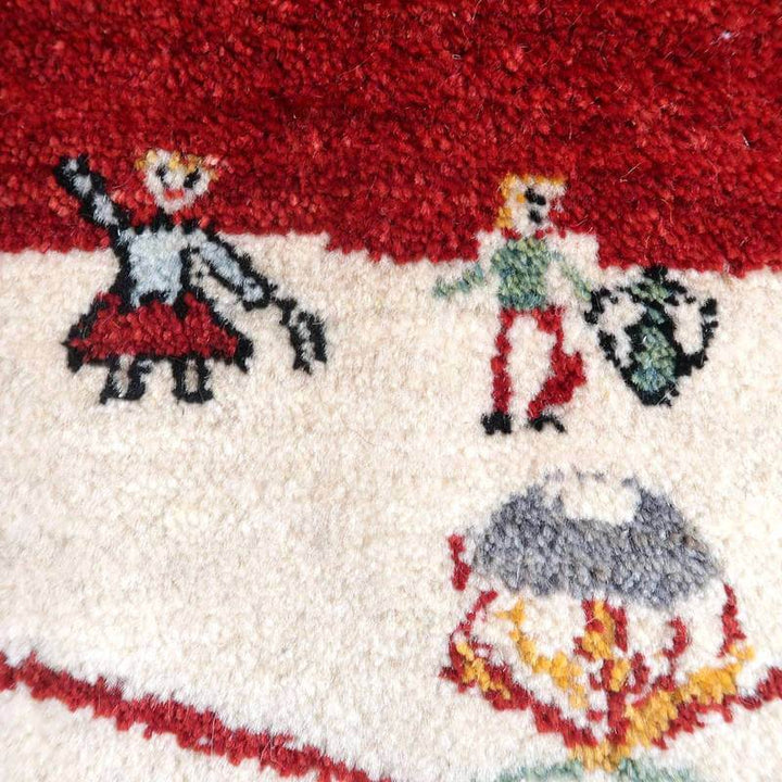赤と白の鮮やかな手織りのギャッベラグに描かれた可愛らしい人物模様が、ウールの温かみとともに専門店通販で購入できるペルシャ絨毯の魅力が際立っている。