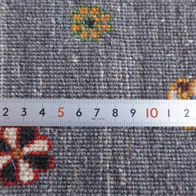 手織りのギャッベラグの織り目が密に詰まった美しい模様が、定規で測られたウールの質感と共に際立っている。