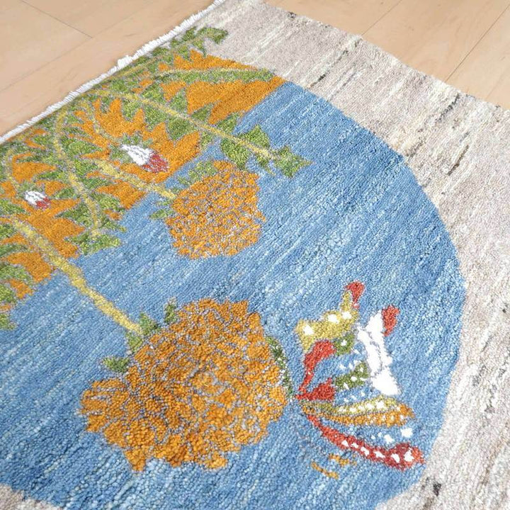 手織りのウールを使用し、鮮やかな青とオレンジの模様が際立つギャッベラグが床に敷かれている。