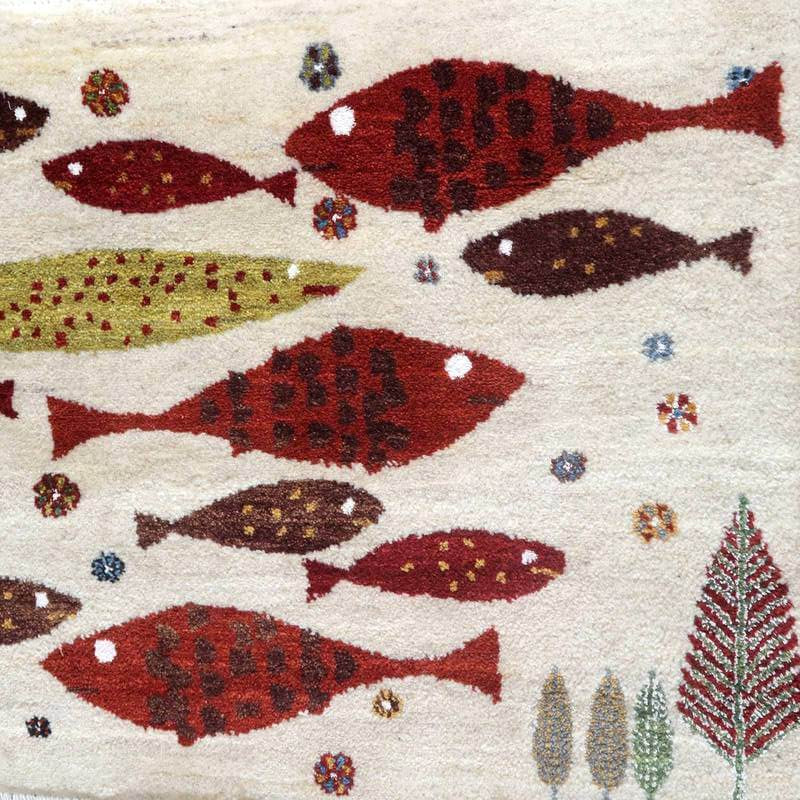 色鮮やかな魚と葉のモチーフが織り込まれた手織りのギャッベラグが、ウールの温もりを感じさせつつ床に広がっています。