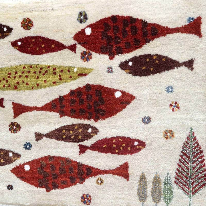 色鮮やかな魚と葉のモチーフが織り込まれた手織りのギャッベラグが、ウールの温もりを感じさせつつ床に広がっています。