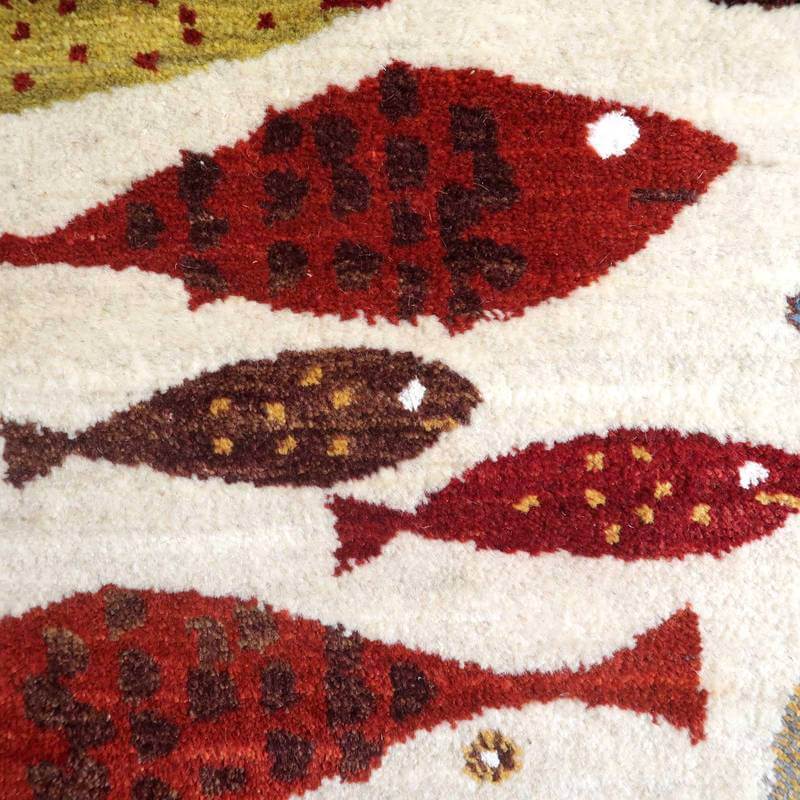 赤や茶の魚柄が丁寧に織り込まれた手織りのギャッベラグが、ペルシャ絨毯専門店の通販で見つかります。