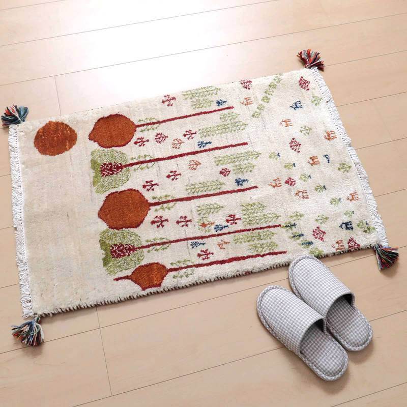 手織りの温かみが感じられるギャッベラグが床に敷かれ、赤や緑の模様がペルシャ絨毯の伝統を物語っている。