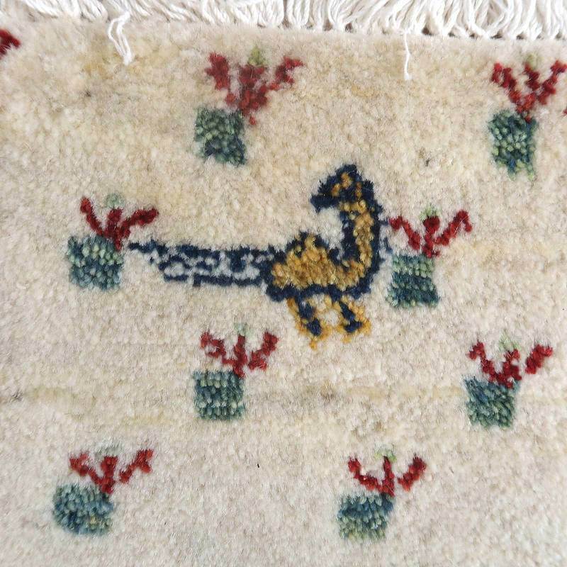 手織りのギャッベラグが、ペルシャ絨毯専門店の通販で人気のウール素材を用い、動物と植物のモチーフが丁寧に織り込まれている。