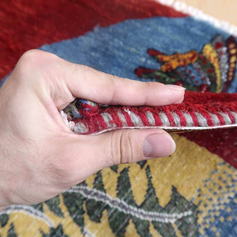 ペルシャ絨毯専門店の手織りギャッベラグが、厚みと色彩豊かなウールの織り目を際立たせている姿が見える。