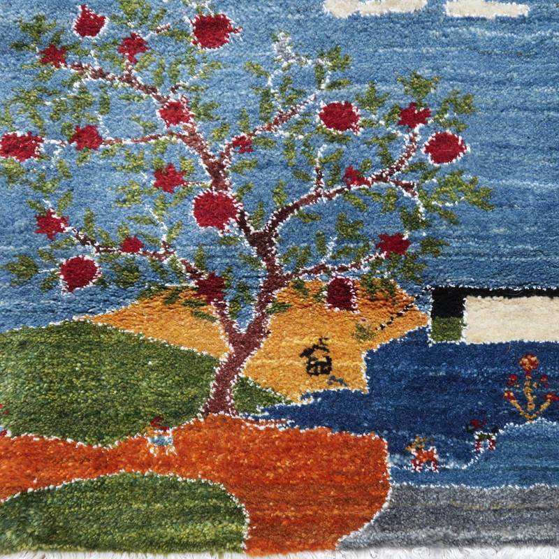 色鮮やかな赤い実をつけた木が描かれた手織りのギャッベラグは、ウールの温かみとペルシャ絨毯の風合いが調和し、通販専門店で人気の一品が際立っている。