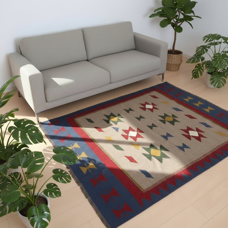 赤いソファの前に、色とりどりの幾何学模様が施された手織りのウール製ギャッベラグが敷かれている。