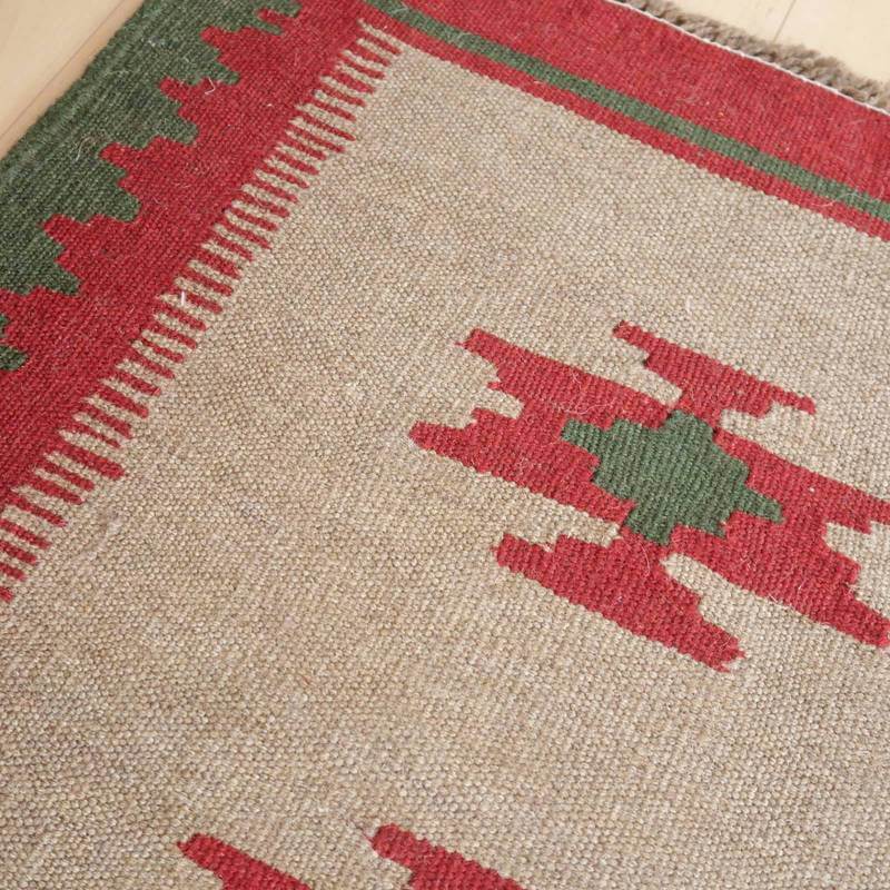 この手織りのギャッベラグは、赤と緑のペルシャ絨毯風の模様がウール素材に丁寧に編み込まれ、専門店の通販で見つかる温かみが感じられる一枚です。