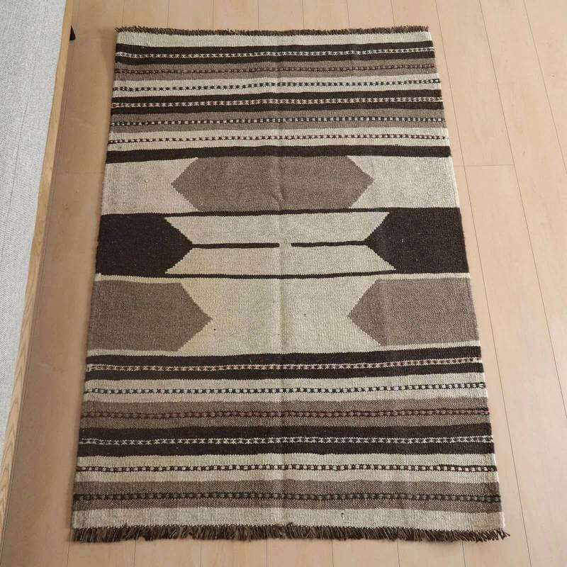 キリム・シラーズ／カシュガイ 152×103cm（KM-817）は、手織りで丁寧に仕上げられたウール素材のギャッベラグが、ペルシャ絨毯専門店の通販で入手可能な落ち着いた色調の幾何学模様が床に敷かれている。