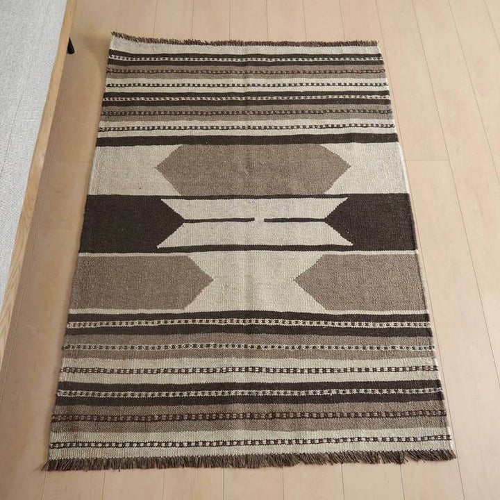 キリム・シラーズ／カシュガイ 149×105cm（KM-818）は、手織りのウール素材で作られたギャッベラグがペルシャ絨毯専門店の通販で購入可能で、シンプルな幾何学模様が木製フローリングの上に美しく敷かれている。