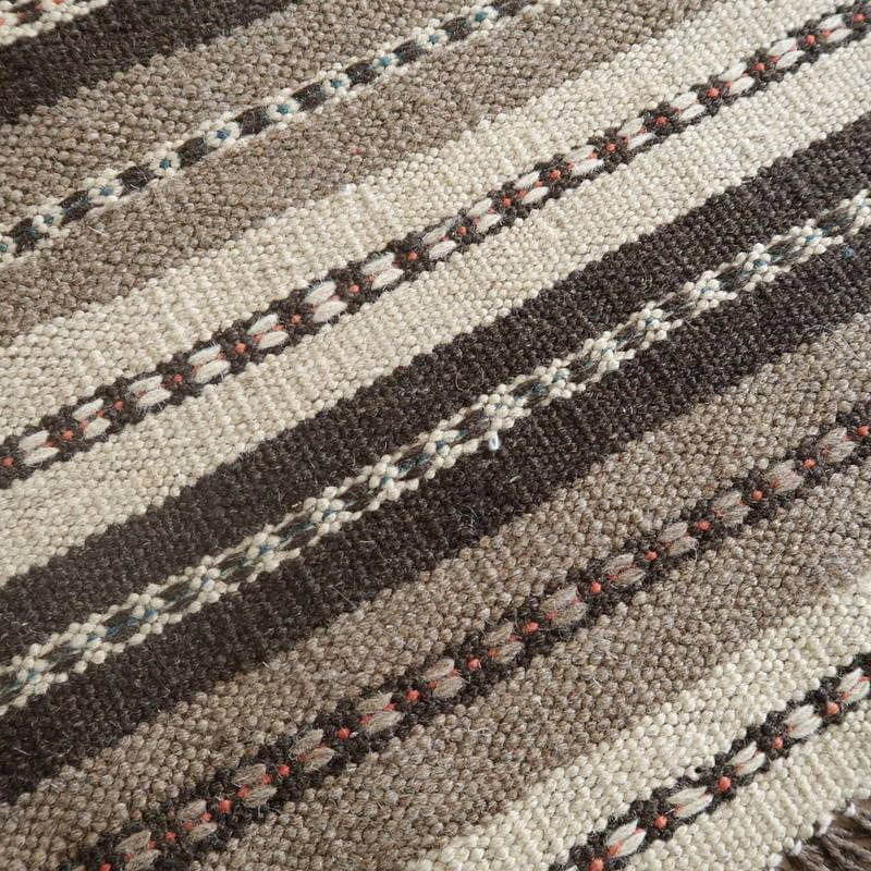 手織りのペルシャ絨毯ギャッベが、ウールのあたたかみとともに落ち着いたストライプ模様で床に映えている。