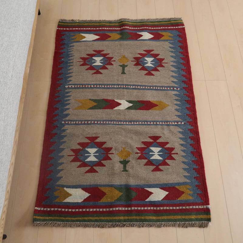 キリム・シラーズ／カシュガイ 149×99cm（KM-841）は、色鮮やかな模様が印象的な手織りのギャッベラグが、ウール素材のぬくもりを感じさせながら床に敷かれている。