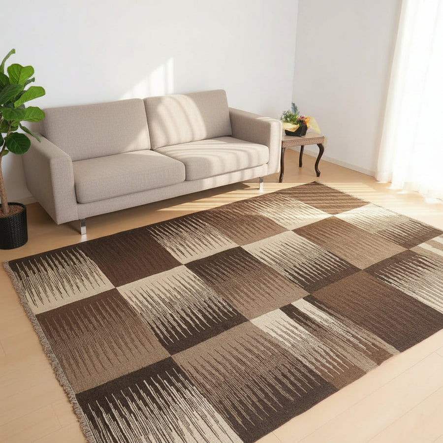 赤いソファの前に、ブラウンとベージュのグラデーションが美しいギャッベラグが敷かれている。