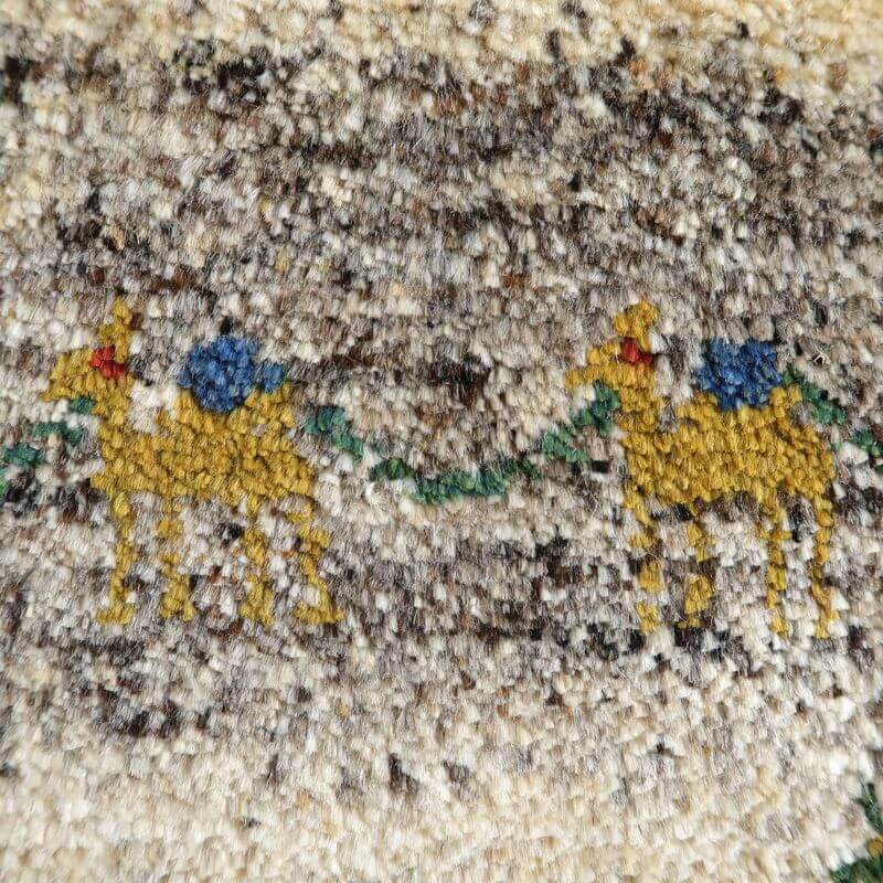 丁寧に手織りされたウールのギャッベには、砂漠を旅するラクダの可愛らしいモチーフが描かれ、リビングやベッドサイドにぬくもりと落ち着きをもたらします。