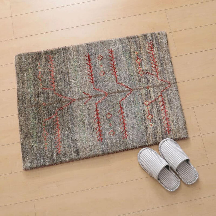 ギャッベ／カシュクリ  88×65cm（ZSS-10771）ゾランヴァリは、床の上にグレーを基調にしたギャッベが敷かれており、隣にチェック柄のスリッパが置かれている。